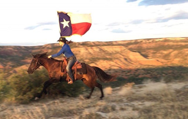 horse and rider carry the Texas flag